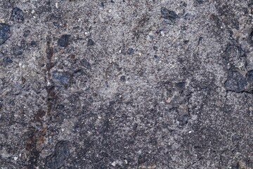 Background texture of an old concrete wall interspersed with black stones. Copy space