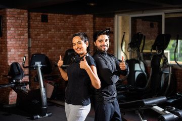 Portrait of Indian asian young Couple working Out Together in Gym, Training With fitness Equipments