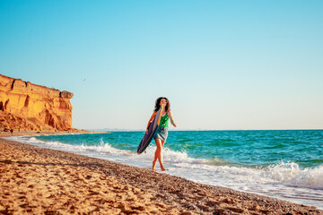 Beautiful sport woman holding the surfboard in the beach and relaxing after surfing on vacation