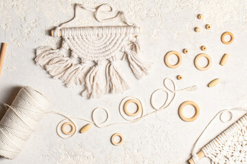 Macrame accessories on cream color background. Creative hobby concept. Top view