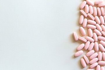 Pink pills on grey background with space for text