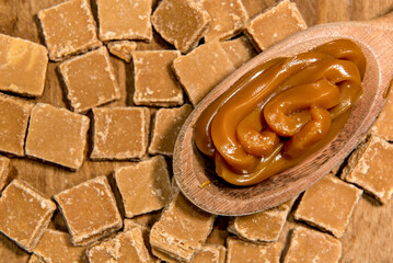 Dulce de leche candies background with wooden spoon full of dulce de leche.