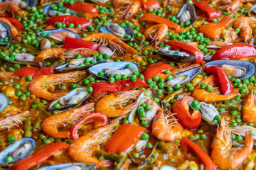 Spanish seafood paella in fry pan with mussels, shrimps and vegetables