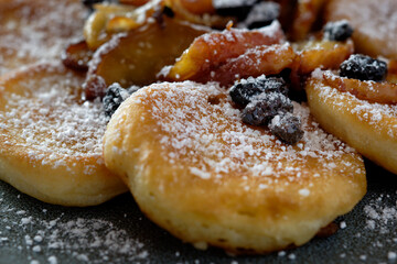 Apple pancake with caramelized apple slices and raisins, with powdered sugar