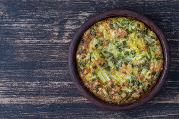 Ceramic bowl with vegetable frittata, simple vegetarian food. Frittata with egg, pepper, green onions and cheese . Healthy egg omelet