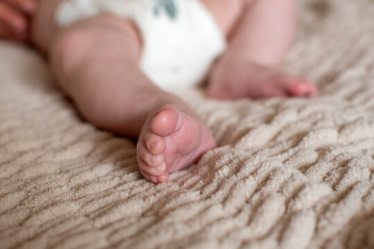 Small child is sleeping in a diaper. Adorable baby feet closeup. Cute little infant sleeping. Selective focus. 