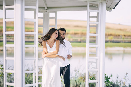 A Woman Feels Happy In The Arms Of A Man. The Couple Hugs And Sm