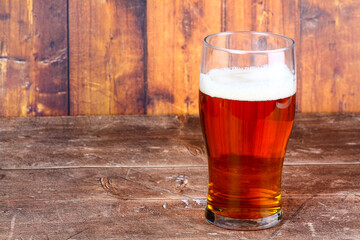 Pint glass filled with craft ale on a wooden background