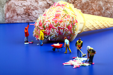 Miniature figure people topping an ice cream cone with hundreds and thousands