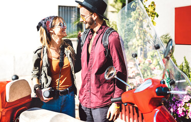 Young tourist couple having fun together at scooter moped ride - Hipster guy having fun outdoors with beautiful girlfriend - Happy travel mood and life style concept on spring day - Warm bright filter