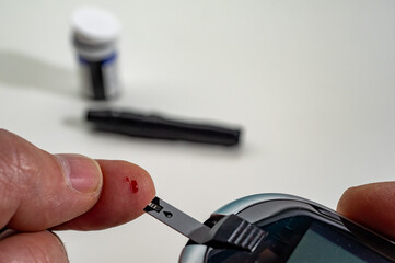 Close-up Of A Man's Hand Checking Blood Sugar Level With Glucometer