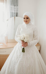 Fototapeta na wymiar Beautiful young muslim woman. Muslim bride before wedding, wearing white hijab in front of mosque. Sharia wedding.