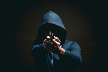 holding a gun on a dark background