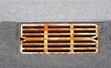 Rusty drain grating on the road, isolated close-up