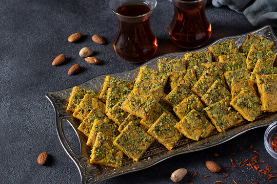 Traditional Persian dessert Sohan from Iran. Tea ceremony with sohan on gray background.