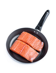 Fresh salmon steak in black frying pan isolated on white. Ready for cooking