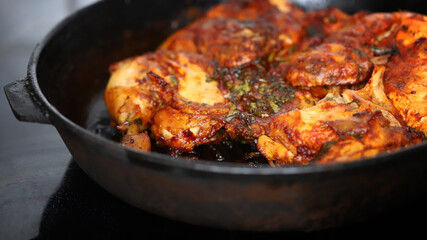 Appetizing grilled chicken in a cast iron pan.