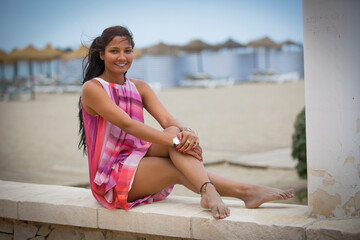 Fototapeta na wymiar Young beautiful woman on the beach with colorful outfit