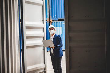 Businessman, executives and engineers wear medical face masks and helmet, While inspecting industrial plants and warehouses for international shipping businesses Concepts of import and export