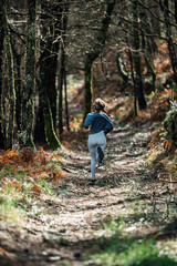 Naklejka na ściany i meble Sporty woman running in forest