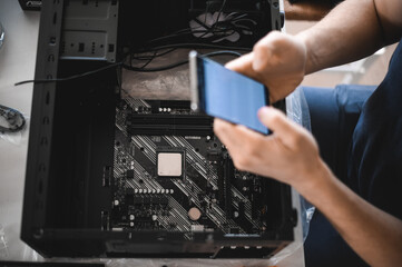 portrait of a handsome nerd man is servicing Computer motherboard and cooler.