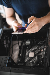 portrait of a handsome nerd man is servicing Computer motherboard and cooler.