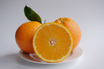 ripe and juicy orange. fresh orange cut in half on a background of oranges with leaves