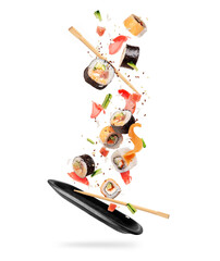 Fresh sushi rolls with various ingredients falling on a black clay plate