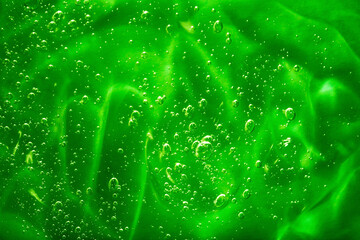 Close up macro Aloe vera gel cosmetic texture green background with bubbles. Lemongrass gel skincare product. antibacterial liquid with aloe vera, moisturizing. Safe and environmental friendly.