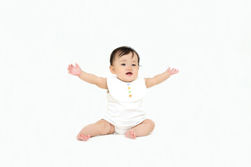 白背景でお座りする女の子の赤ちゃん。成長,健康,元気,育児イメージ