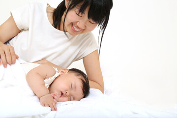 Obraz na płótnie Canvas 寝ている赤ちゃんに優しく手で触れる母さん。育児、母子、愛情イメージ