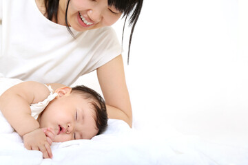 寝ている赤ちゃんに優しく手で触れる母さん。育児、母子、愛情イメージ