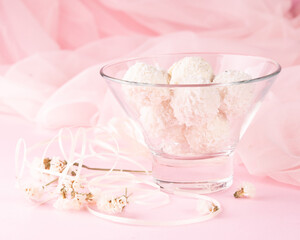 Delicious delicate candies in a glass candy bowl on a pink