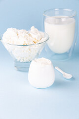 Glass of milk, cottage cheese and sour cream on a blue