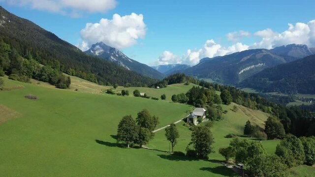Une route menant &agrave; un chalet entour&eacute; des prairies en herbe, des for&ecirc;ts et des montagnes verdoyantes verdoyantes vers Saint-Pierre-d'Entremont, dans le massif de la Chartreuse, dans les Alpes, en Is&egrave;re