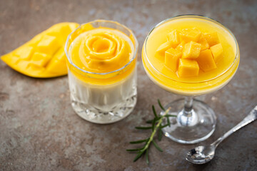 Italian dessert panna cotta with mango in glass on gray background