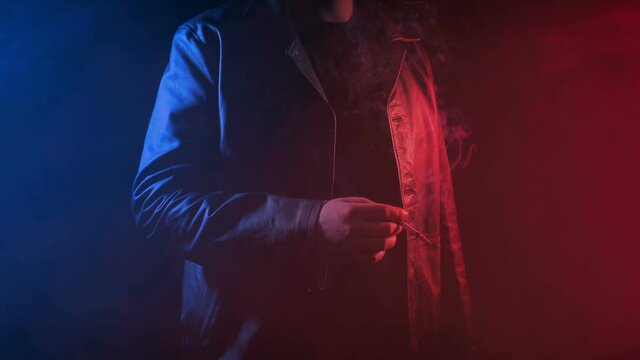 Man Smokes In Neon Lights And Haze