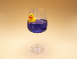yellow rubber duck on pink background in blue water