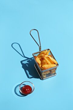French fries with ketchup. Hard light, blue background