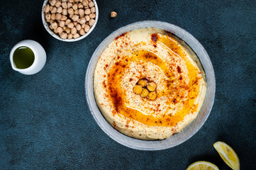 Traditional Middle east appetizer Hummus served with lemon and tahini, seasoned with extra virgin olive oil and paprika in ceramic plate. eastern dish. Vegetarian dish. Traditional dip with chickpea