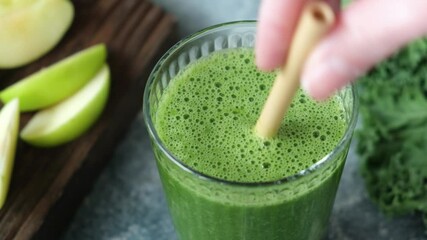 Detox green smoothie in glass with drinking straw. Healthy detox green juice smoothie drink