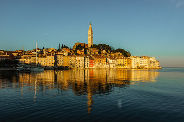 Fototapeta na wymiar Rovinj,Istria,Croatia.View of the town situated on the coast of Adriatic Sea.Popular tourist resort and fishing port.Old town at sunrise with cobblestone streets, colorful houses and the church tower