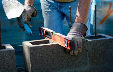 Construction site: building wall of concrete block. Checking level.