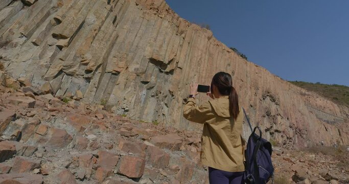 Woman visit geo park and take photo on cellphone