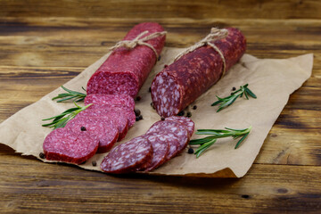 Salami sausages on craft paper on a wooden table