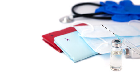 Influenza and coronavirus vaccination before travel. Vaccine, syringe, masks and two passports on a white background. Safe travel concept. Close-up. Copy space.