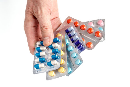 Drug prescription for treatment medication.Close-up of hand holding medication blister packs of tablets and capsules against . Pharmaceutical medicament, cure in container for health. Pharmacy theme