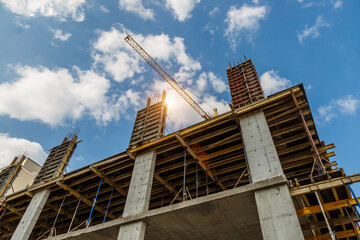 Extensive scaffolding providing platforms for work in progress on a new apartment block,Tall building under construction with scaffolds,Freestanding tower crane on a building site