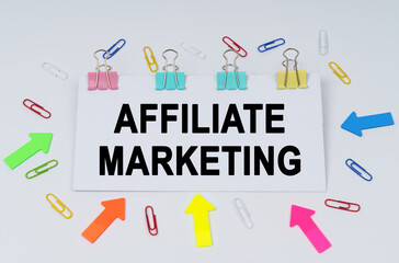 On the table there are paper clips and directional arrows, a sign that says - AFFILIATE MARKETING