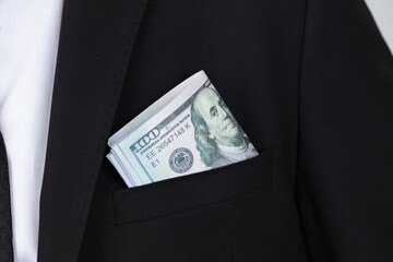 Money success concept. 100 dollar bills in businessman jacket pocket. Symbol of success and wealth.